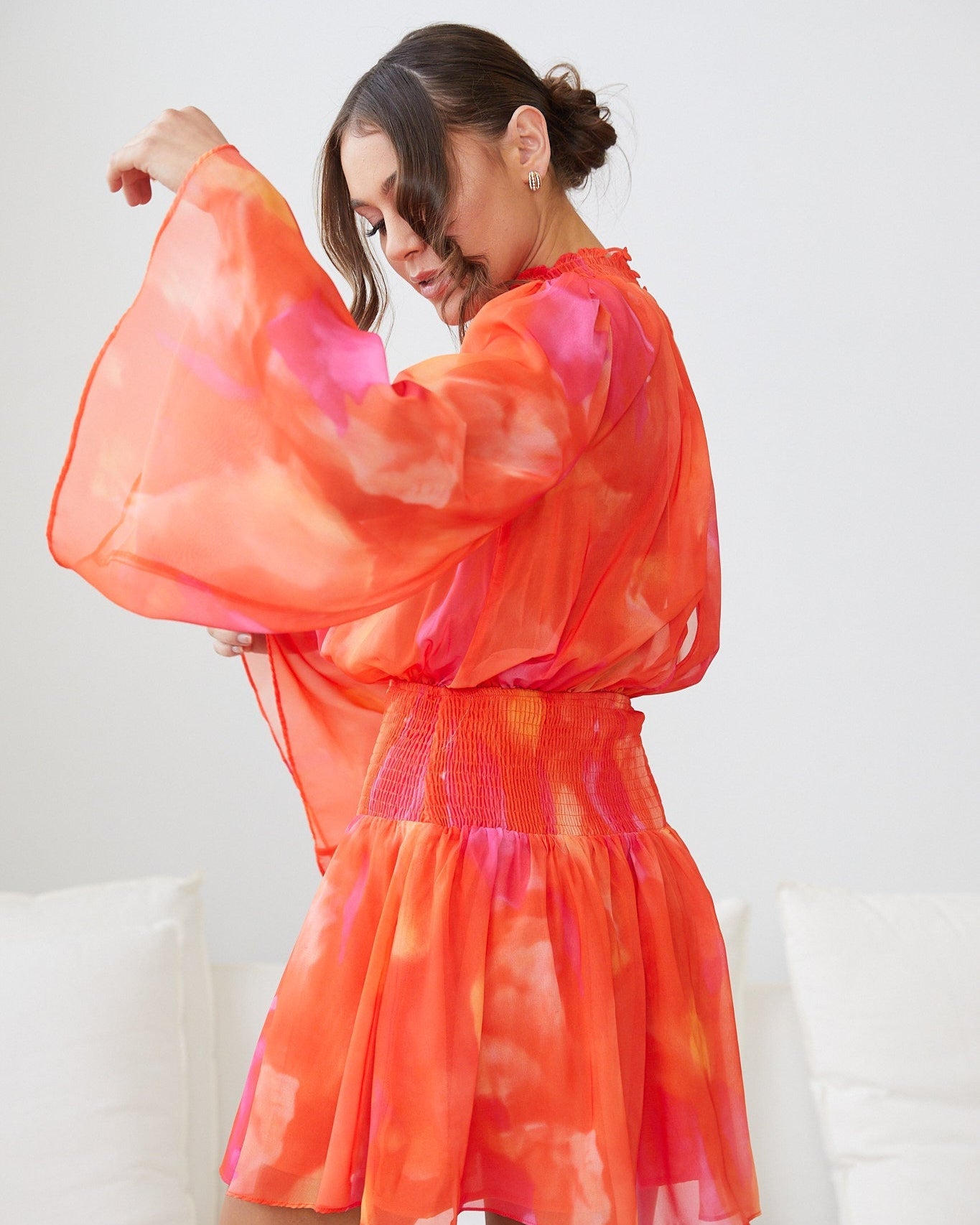 Side view of the Daenerys Orange Print Mini Dress showing the A-line silhouette and long sleeves