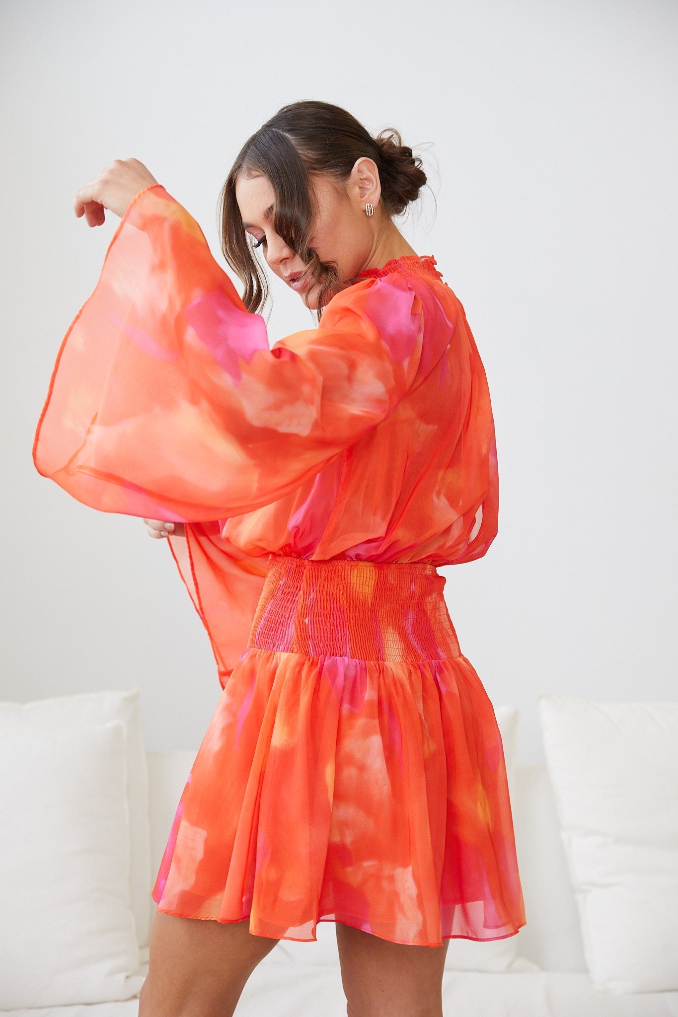 Side view of the Daenerys Orange Print Mini Dress showing the A-line silhouette and long sleeves