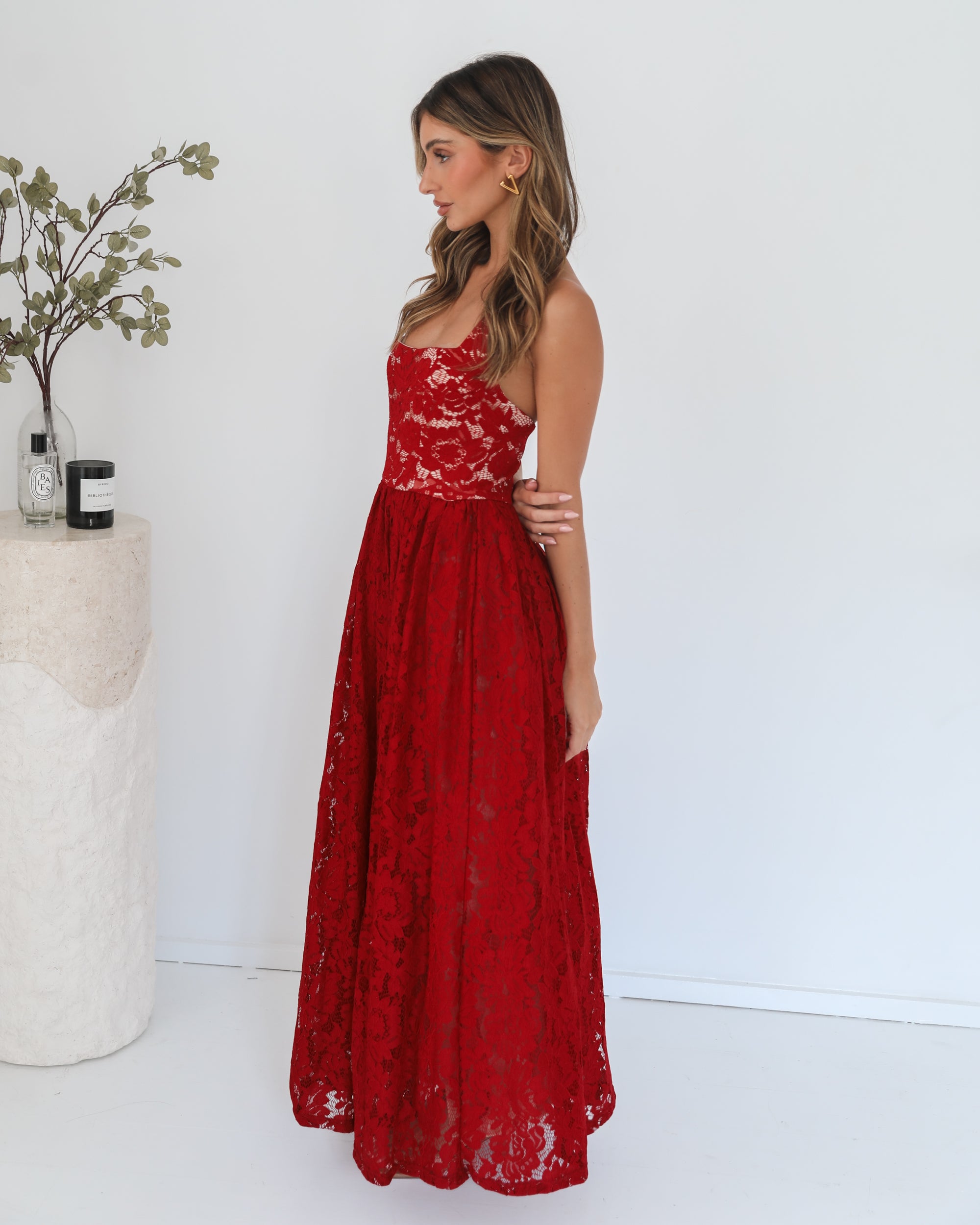 A woman wearing a red maxi dress with a halter neckline.