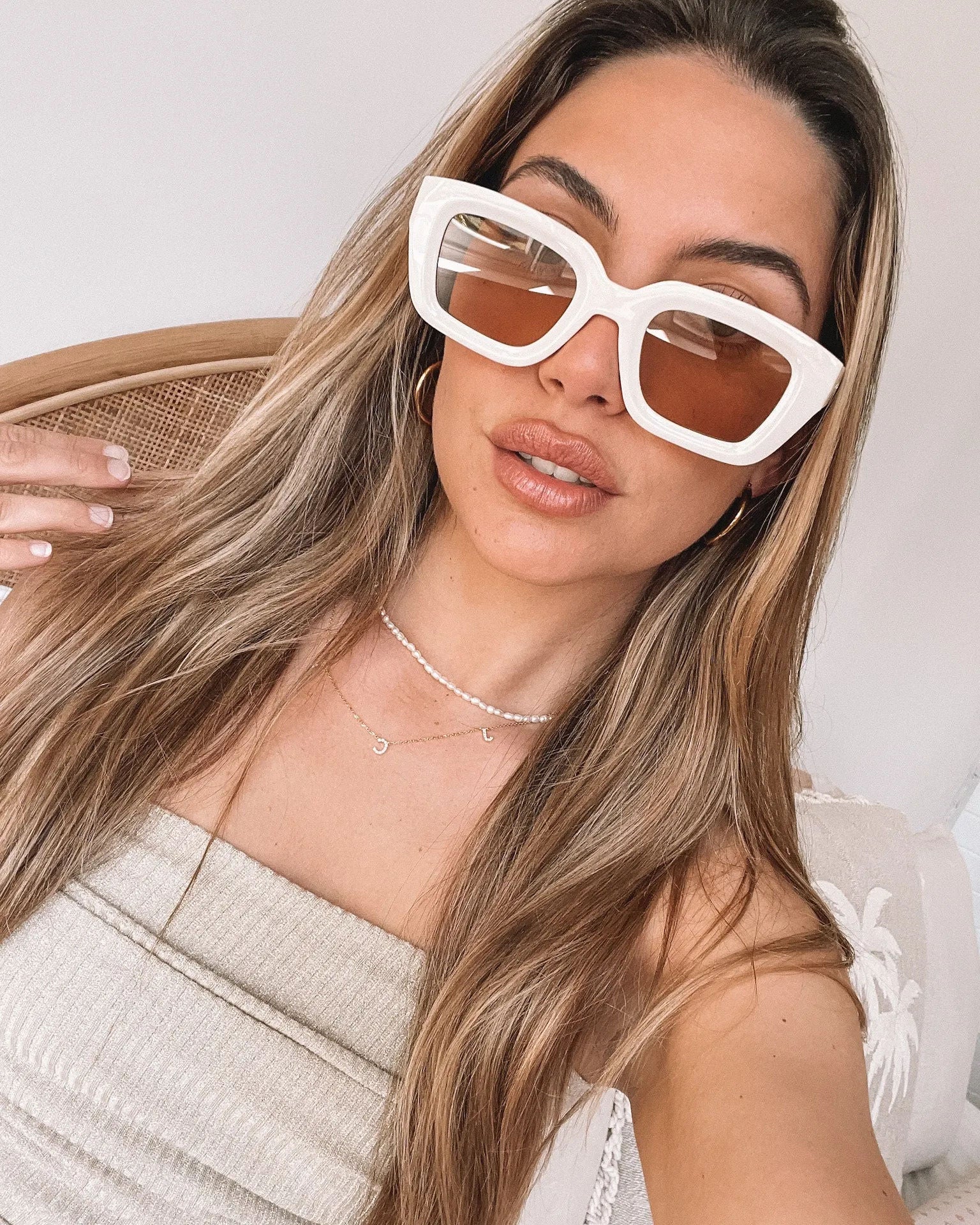 A pair of beige sunglasses displayed on a surface.