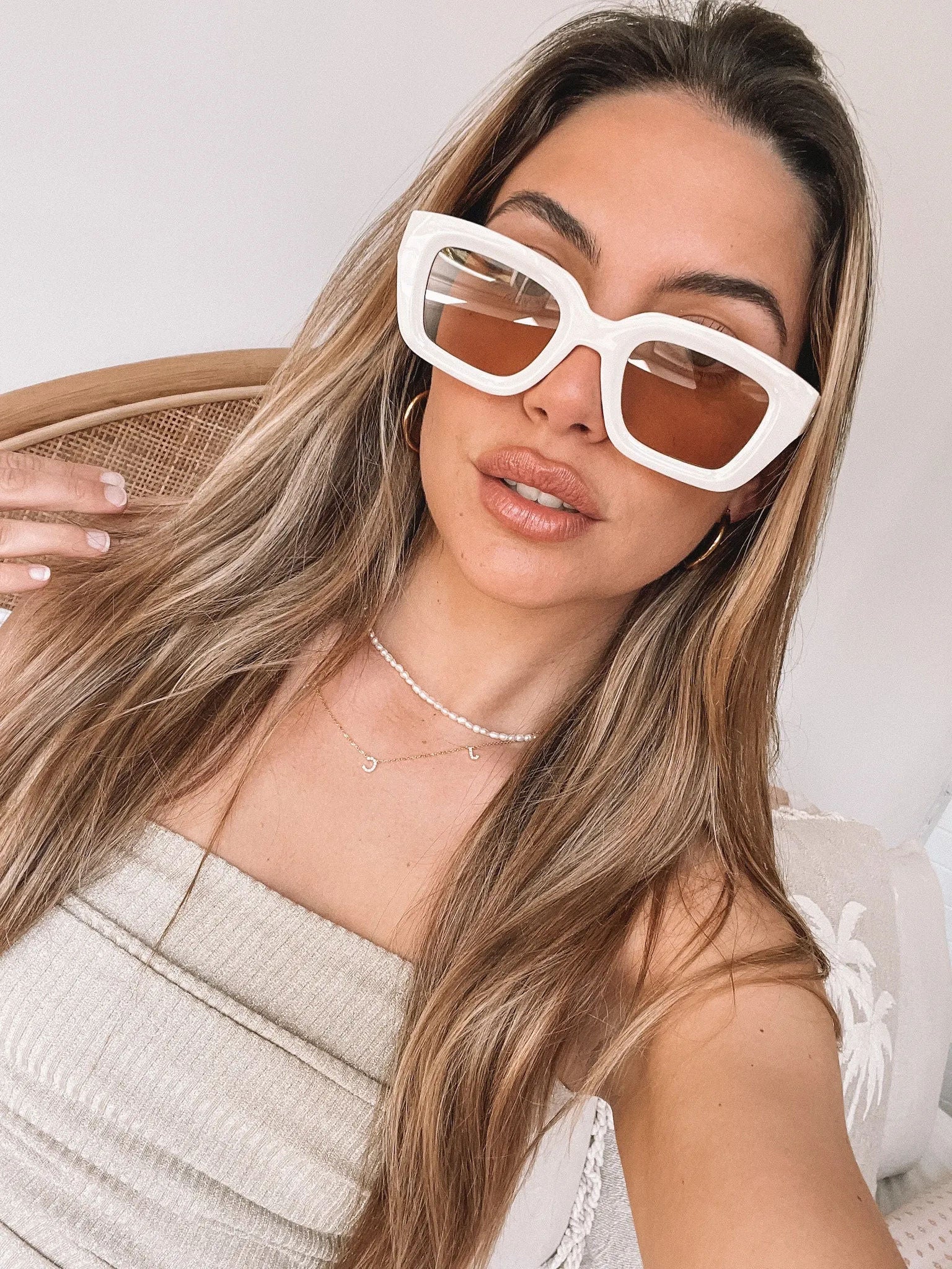 A pair of beige sunglasses displayed on a surface.