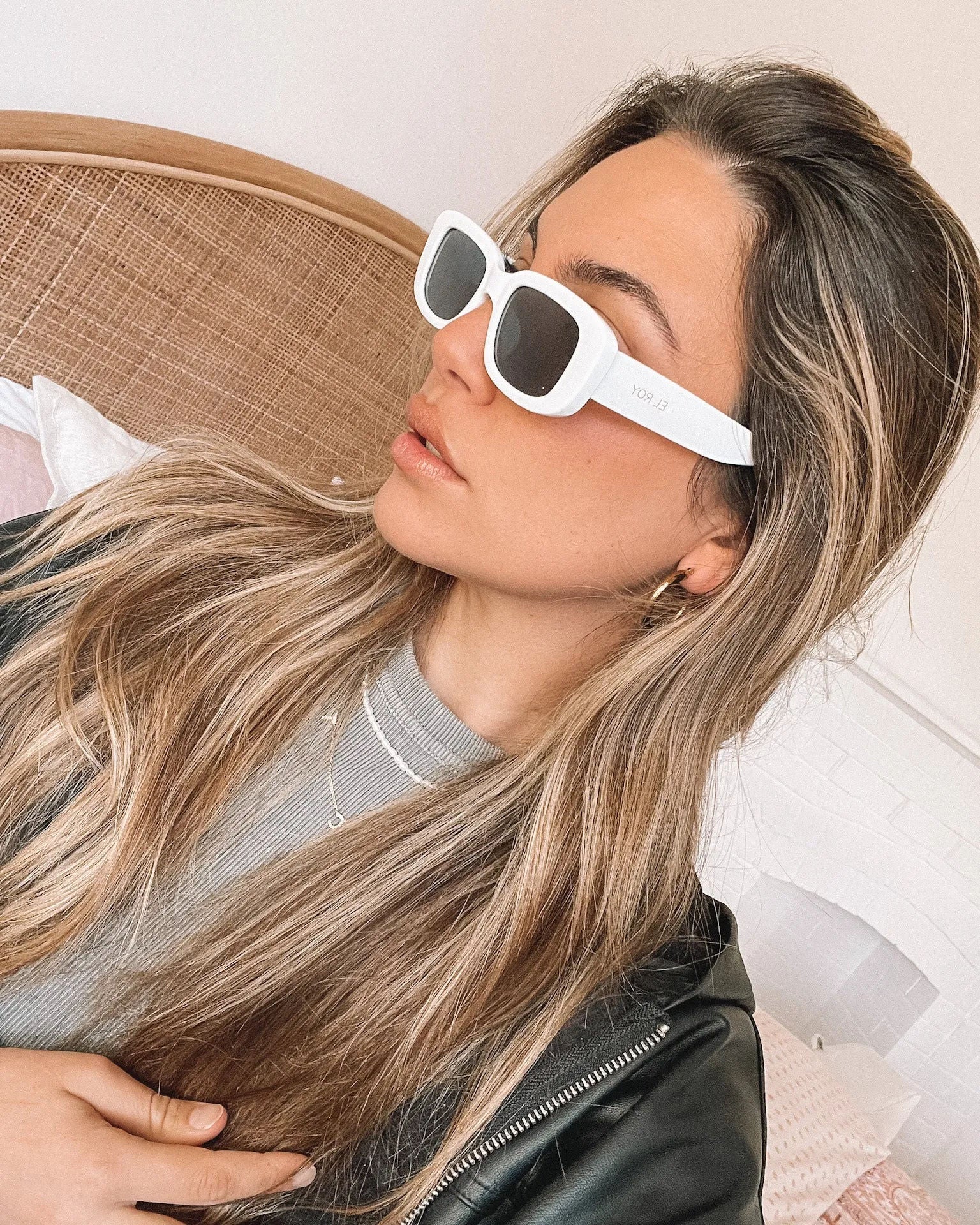 A pair of white-framed sunglasses displayed against a neutral background.