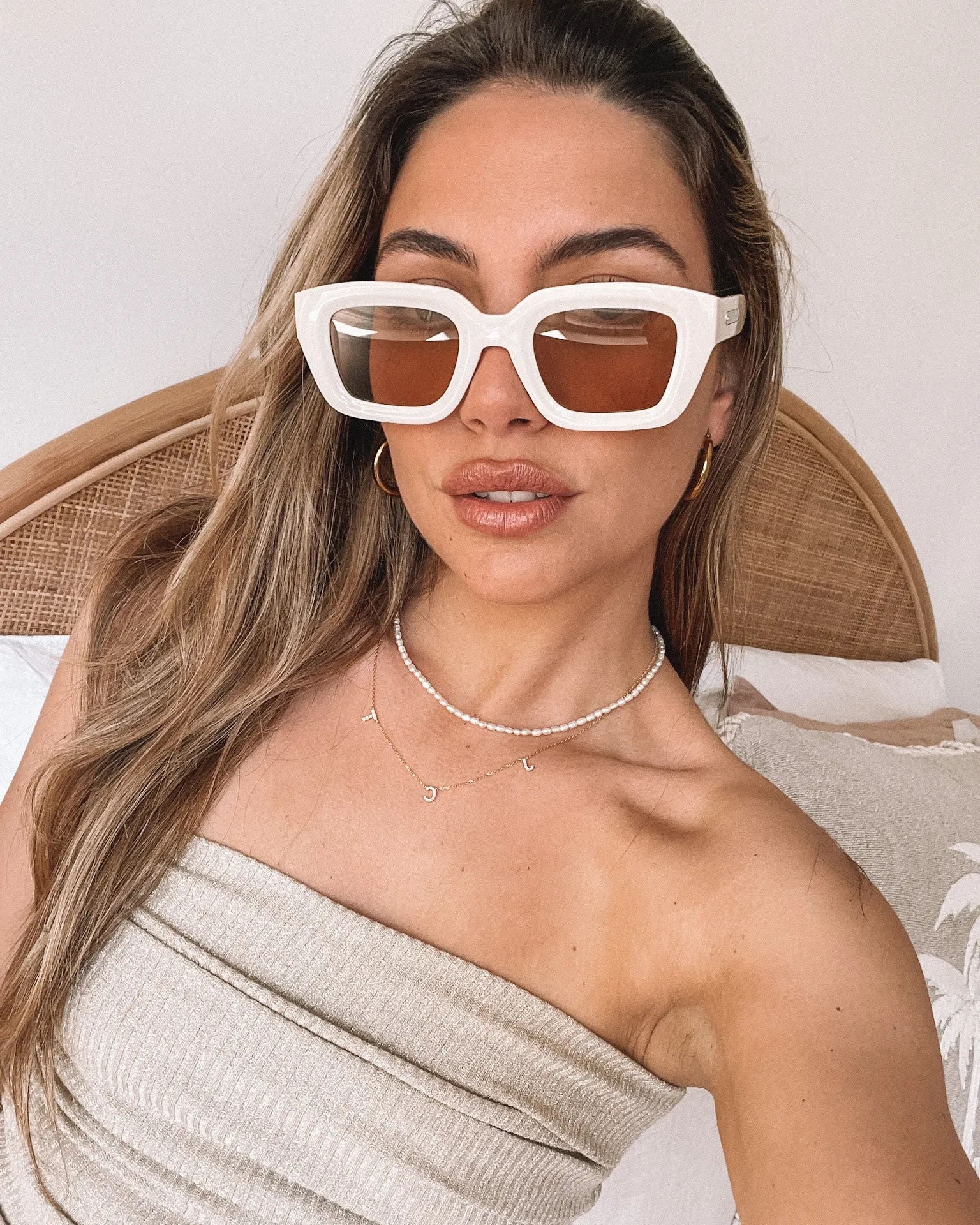 A pair of beige sunglasses displayed on a surface.