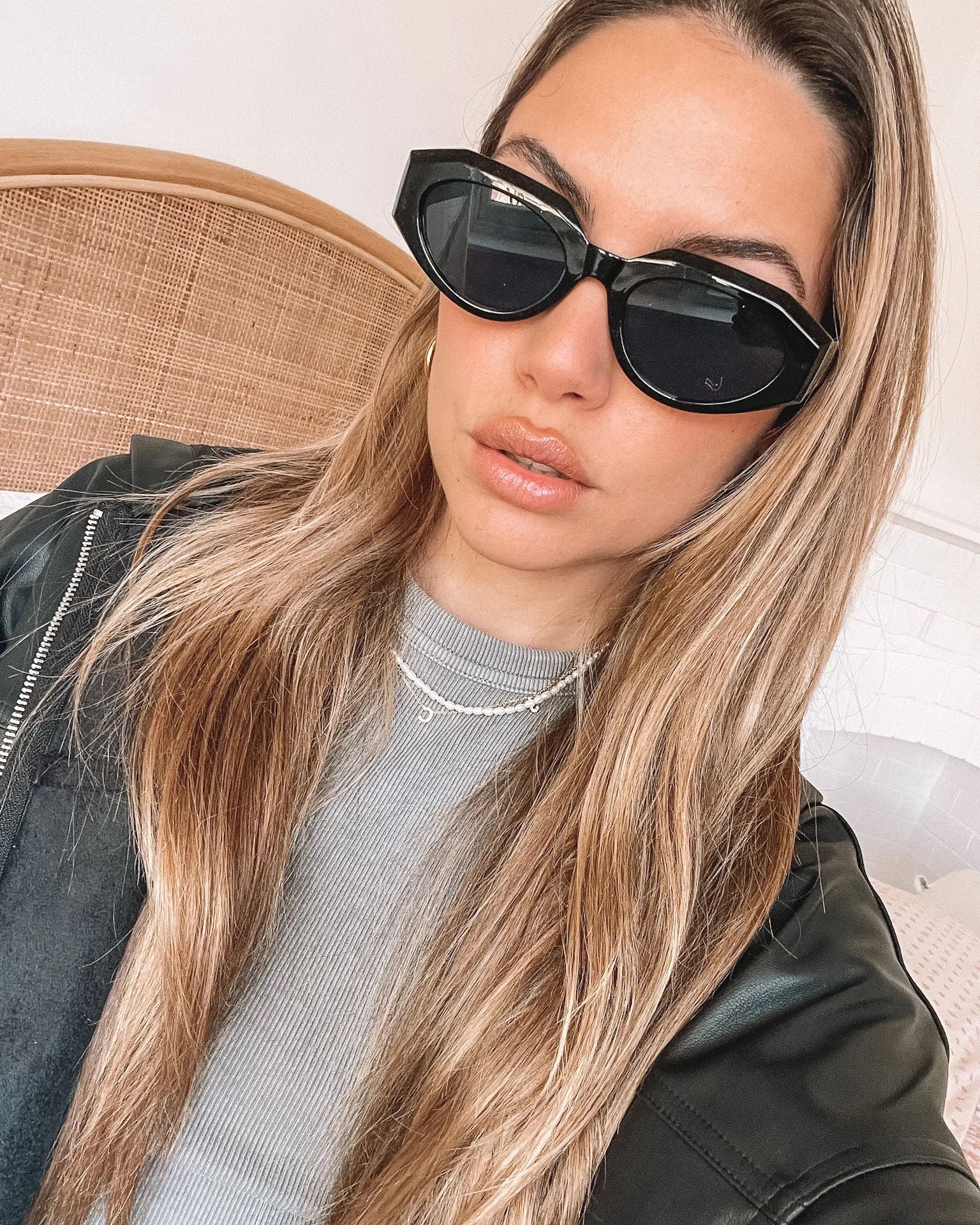 A pair of black sunglasses displayed against a neutral background.