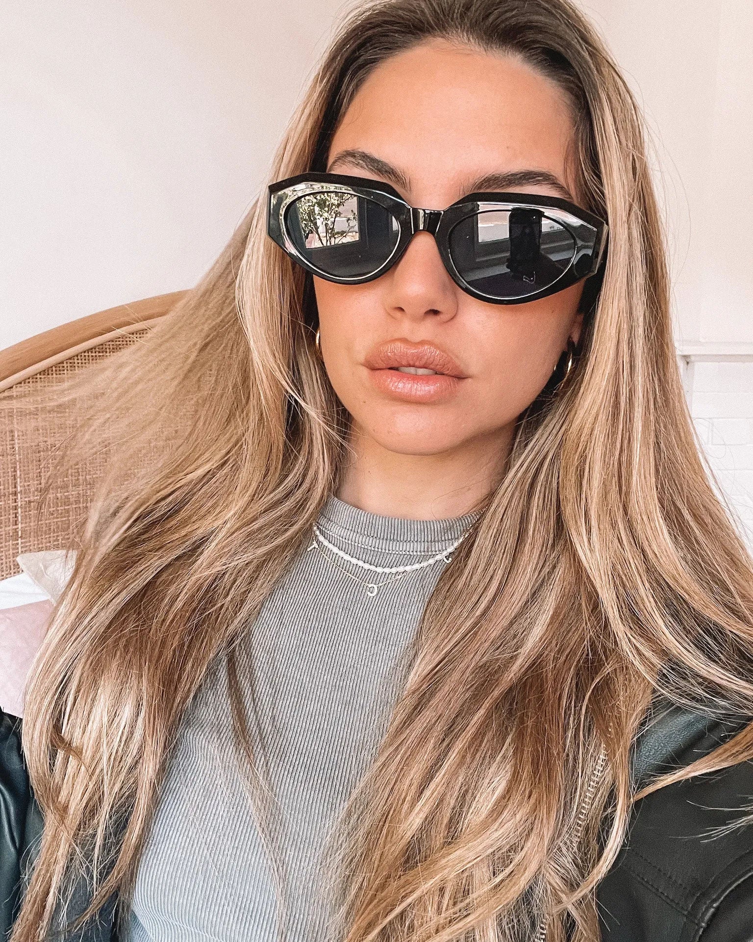 A pair of black sunglasses displayed against a neutral background.