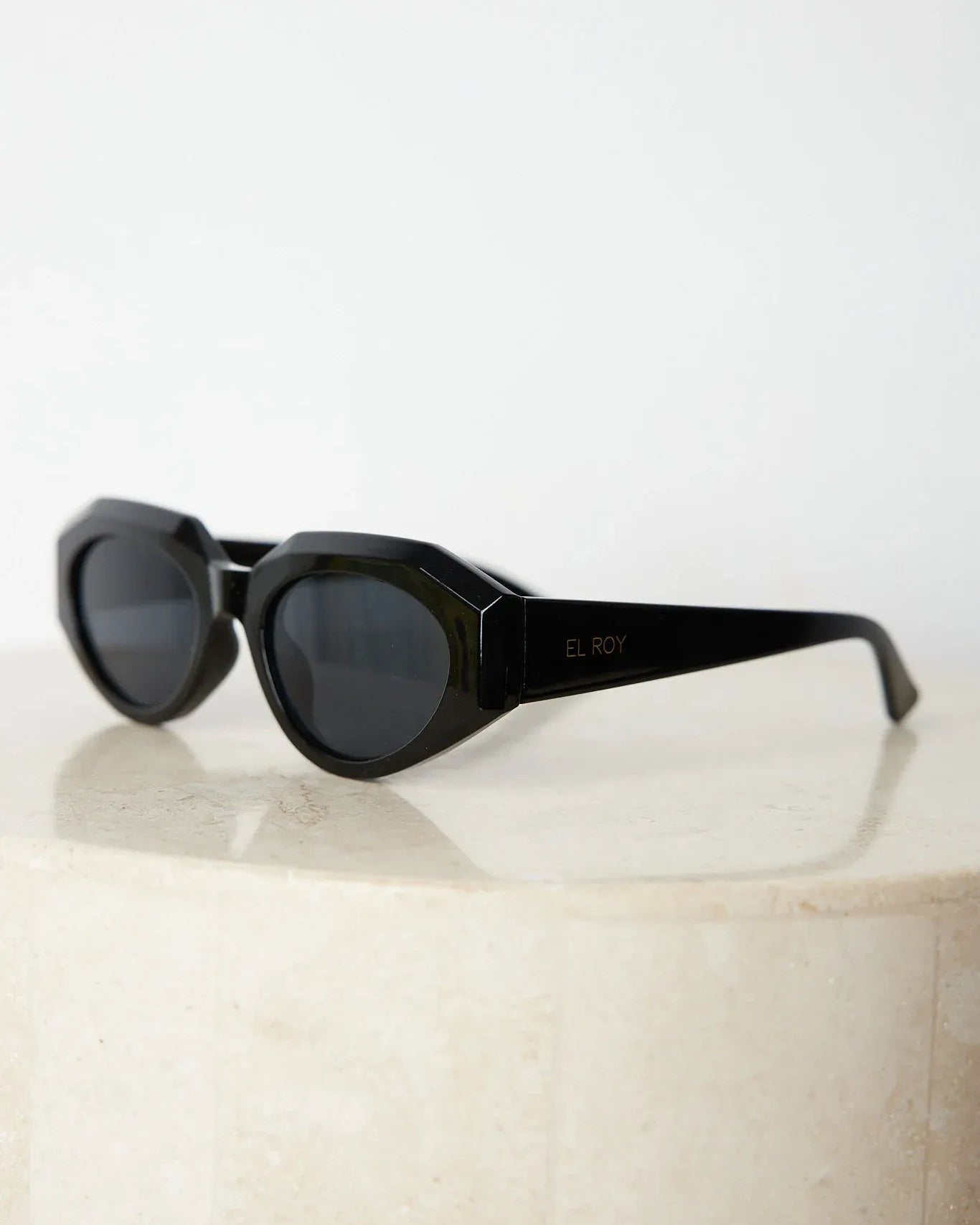 A pair of black sunglasses displayed against a neutral background.