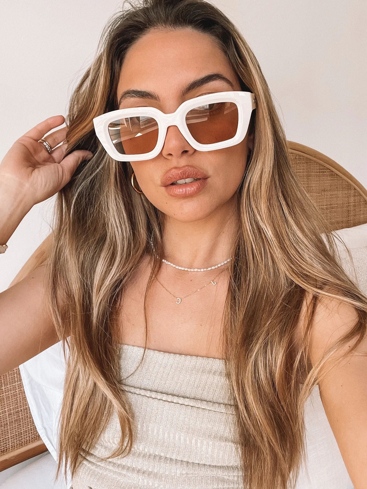A pair of beige sunglasses displayed on a surface.