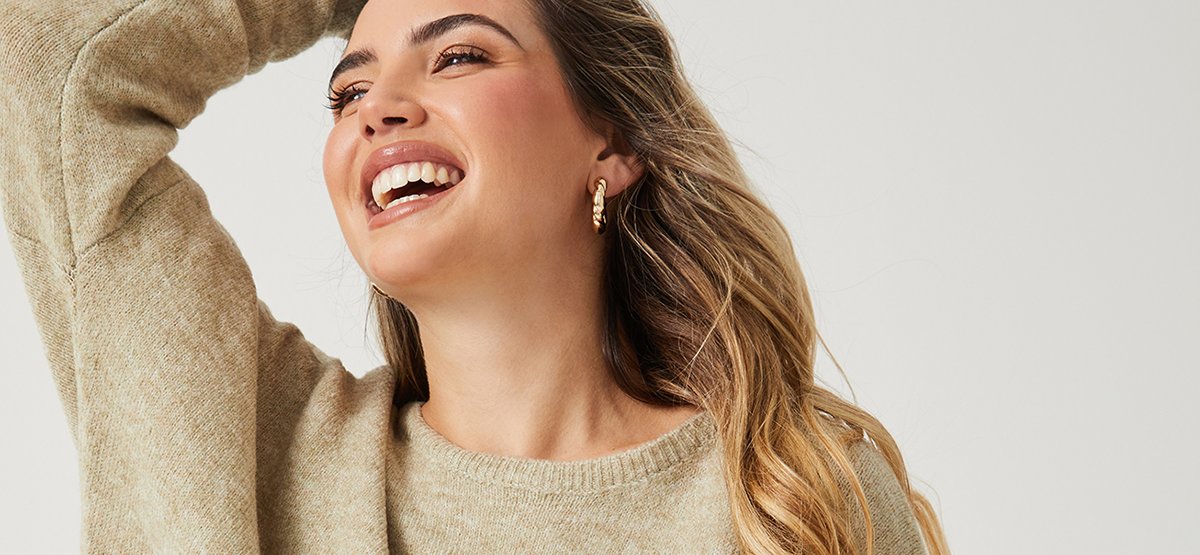 smiling girl wearing a sage round neck knitwear
