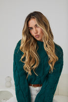 Women wearing the Hadi Knit in Dark Green, a cosy acrylic women's jumper with high round neckline and long sleeves
