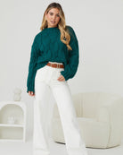 Side view of the Hadi Knit in Dark Green showing the long sleeves and relaxed fit