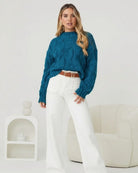 Side view of the Hadi Knit in Teal showing the long sleeves and relaxed fit