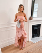 Elegant woman in a pink strapless dress with a ruffled hem, perfect for weddings, formal events, evening balls, and special occasions, standing gracefully.