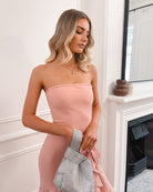 Elegant woman in a pink strapless dress with a ruffled hem, perfect for weddings, formal events, evening balls, and special occasions, standing gracefully.