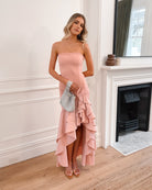 Elegant woman in a pink strapless dress with a ruffled hem, perfect for weddings, formal events, evening balls, and special occasions, standing gracefully.