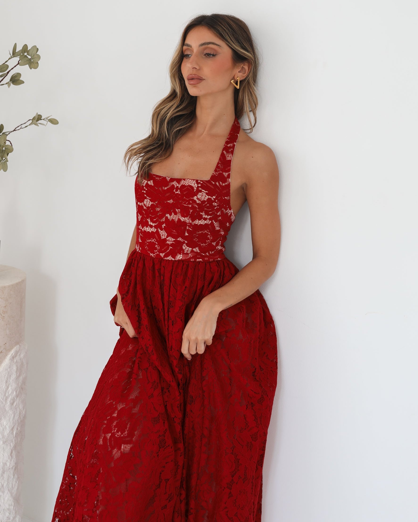 A woman wearing a red maxi dress with a halter neckline.