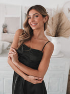 Women's black satin mini dress styled with block heels by Esther & Co
