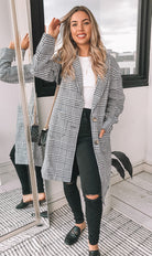 Full length view of the Polaris Coat in Print by Esther and Co showing the classic black white and grey plaid