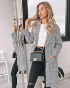 Women wearing the Polaris Coat in black white and grey plaid print, a structured longline coat with button-up front and collar neckline