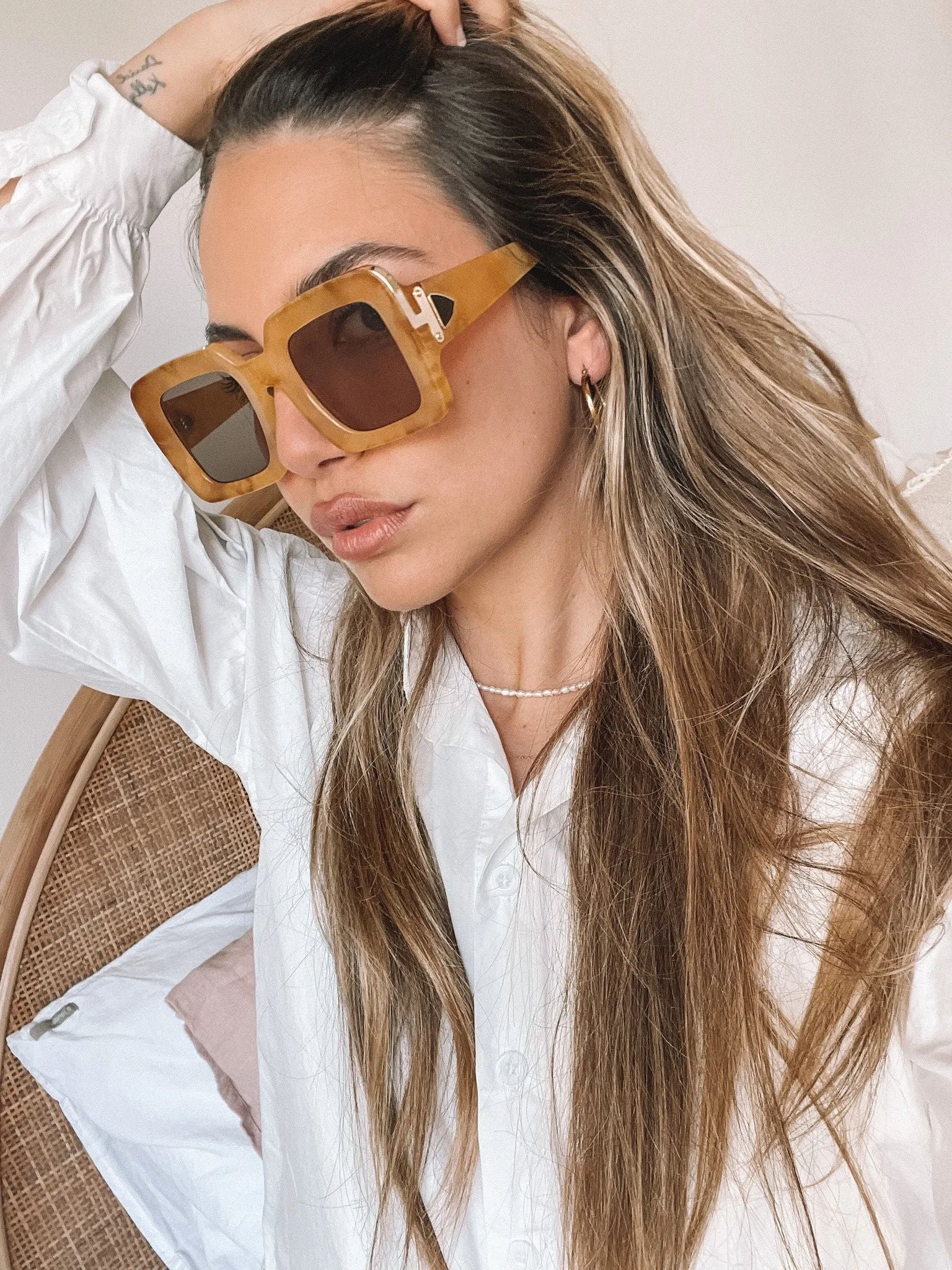 A pair of sunglasses with a tan frame displayed on a surface.
